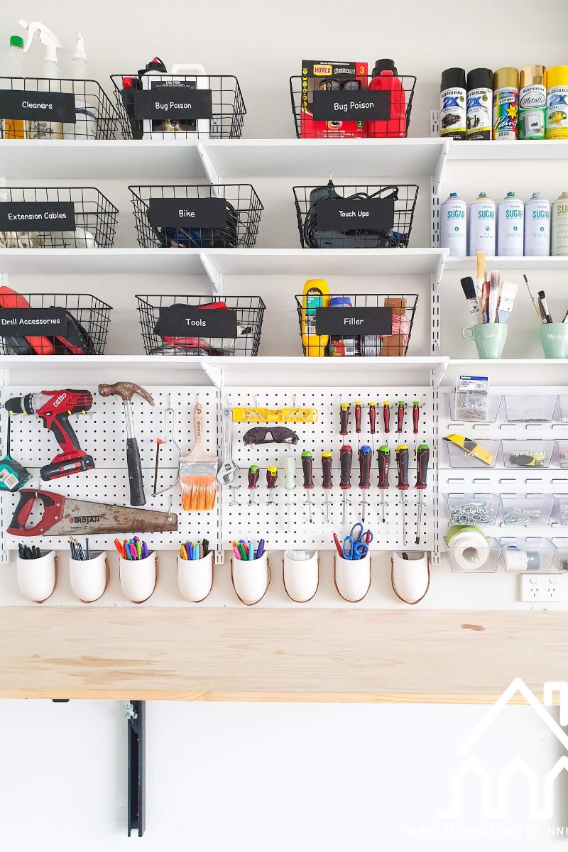 Garage pegboard tool wall with organised hand tools and fold-down workbench