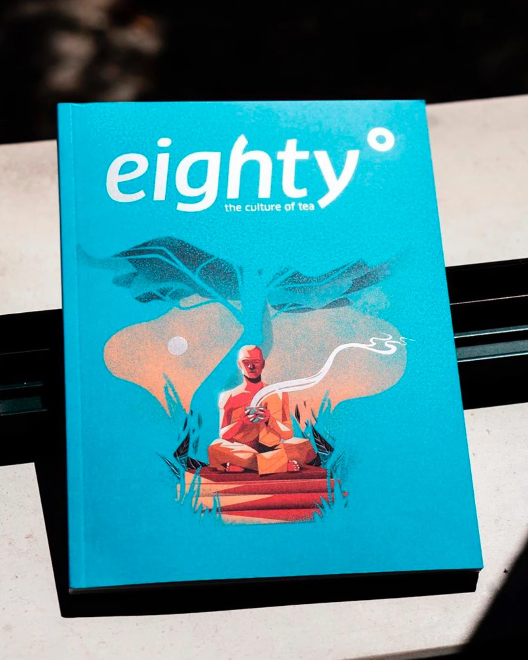 Eighty Degrees tea magazine cover on piano background