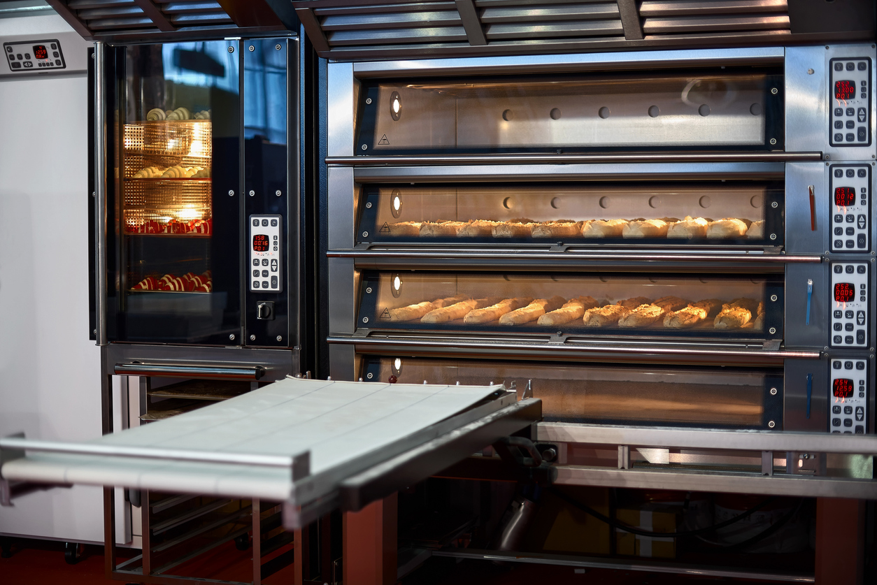 A series of large commercial ovens baking fresh bread