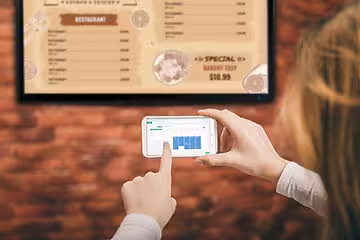 Person using OptiSigns Digital Signage Software's app to push information to their digital sign.