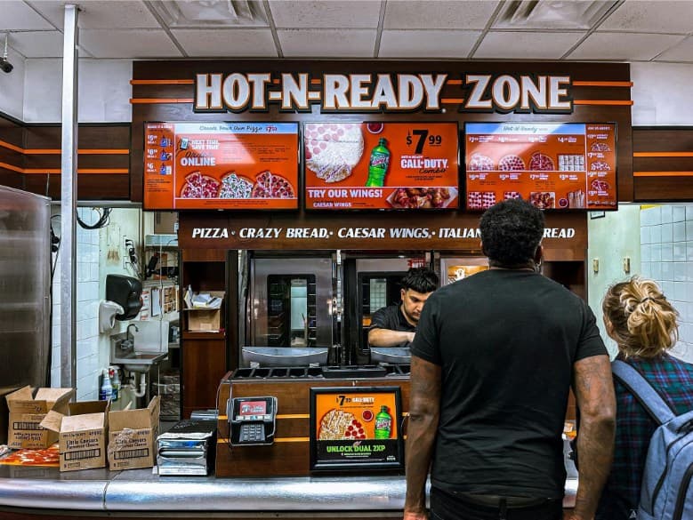 Digital menus inside a pizza restaurant displaying the current specials. 