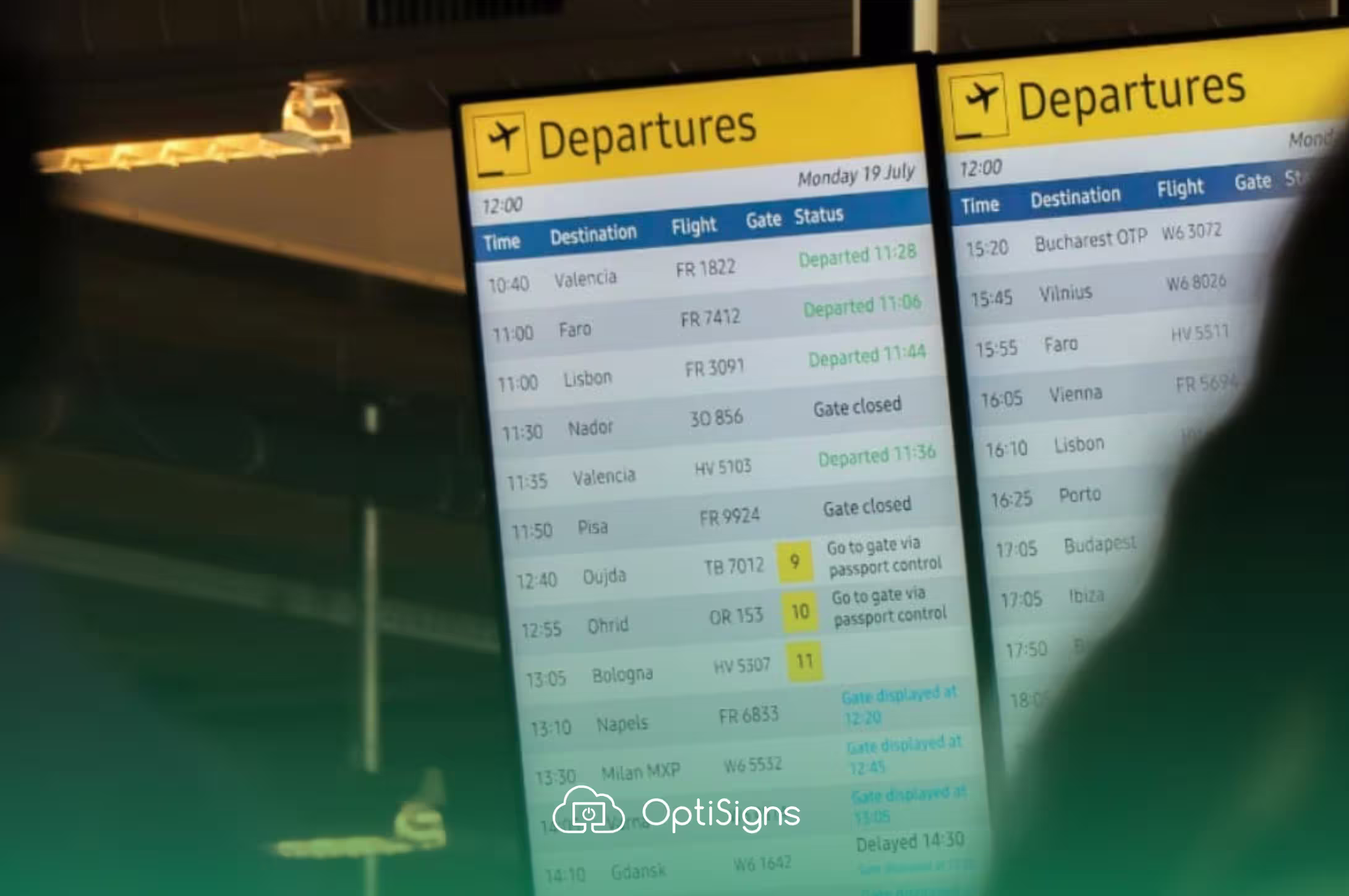 Digital signage inside an airport terminal, displaying flight departure information.