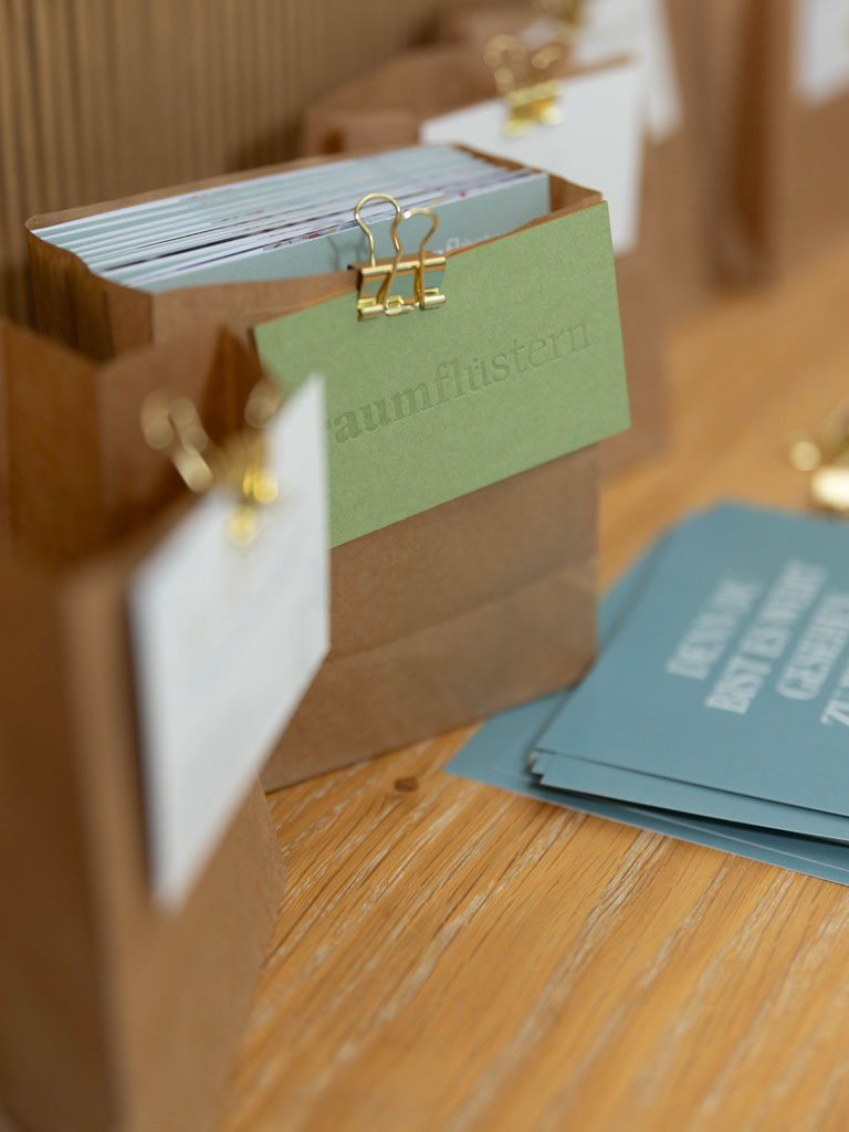 Das Logo des Glow and Grow Netzwerks für Powerfrauen über Visitenkarten-Taschen aus Craft-Paper