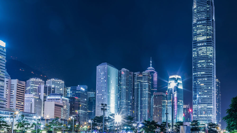 A city at night with tall buildings lit up.