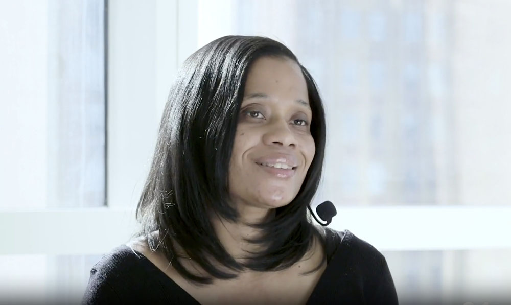 A woman in a black shirt is smiling.