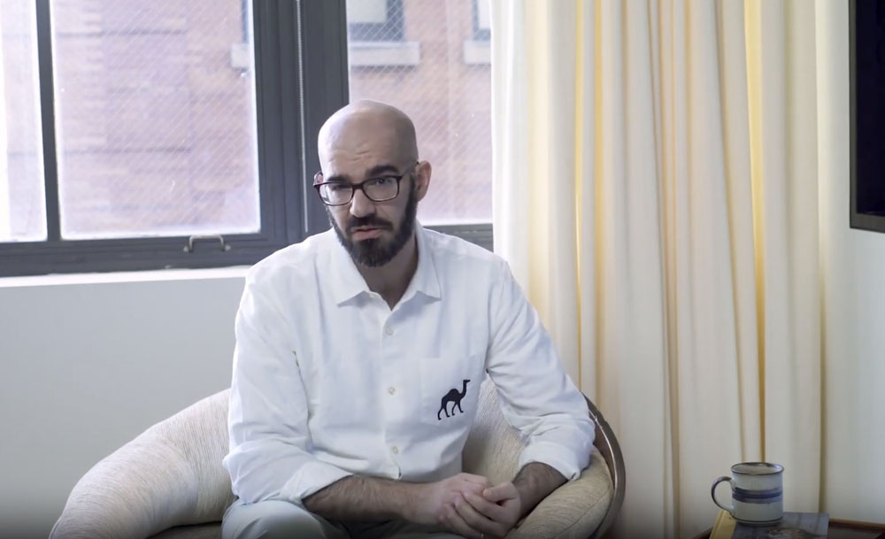 A man sitting in a chair in front of a window.