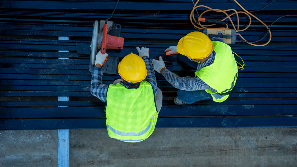 Two construction workers wearing safety vests and hard hats.