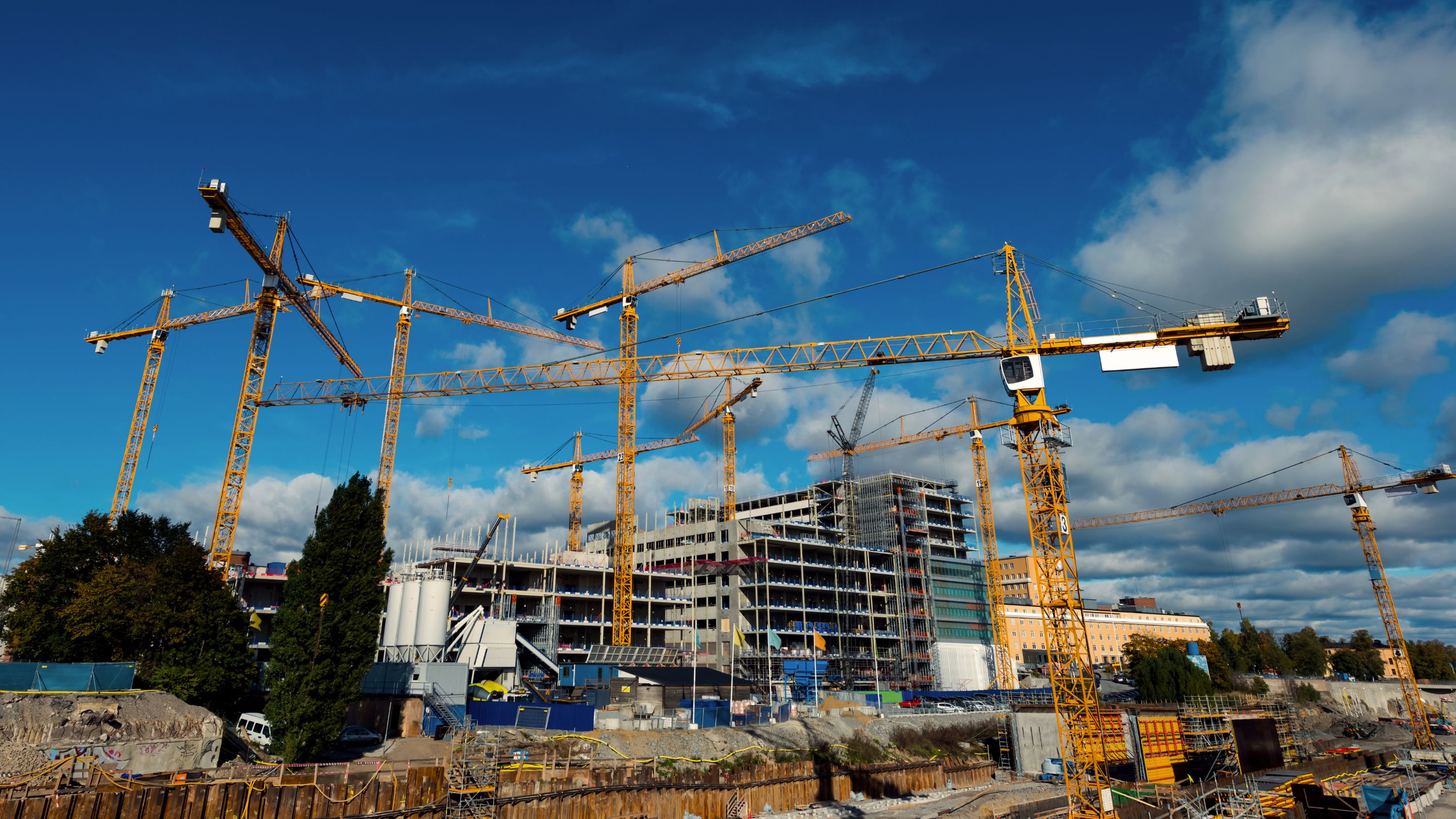 A bunch of cranes that are standing in the air.