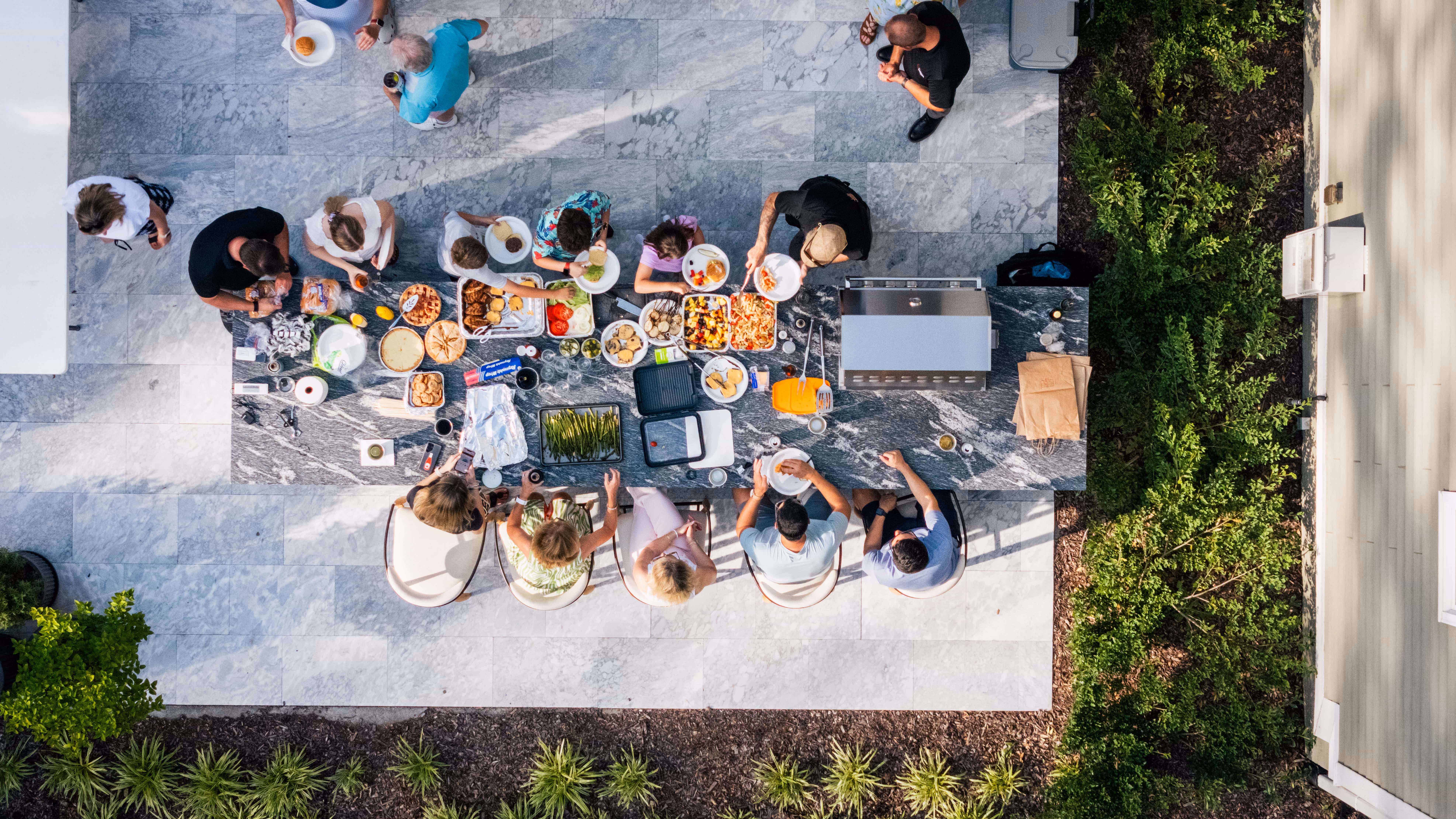 An aerial perspective of a beautiful, custom-designed backyard patio by Currin Outdoor Living, set up for outdoor dining and social gatherings in a private Raleigh, NC residential space.