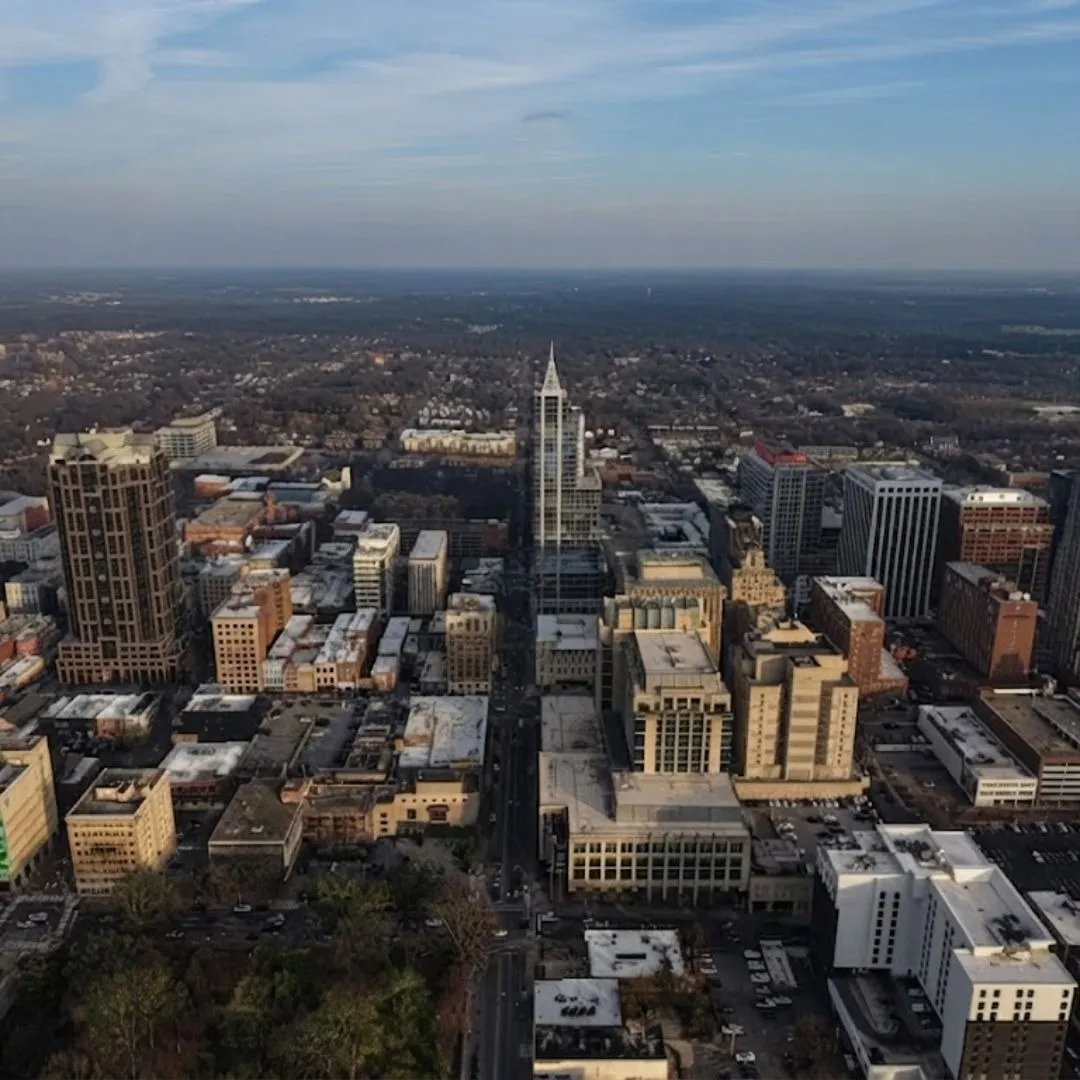 Aerial view of city skyline and urban buildings representing the Garner, NC service area for Currin Outdoor Living.