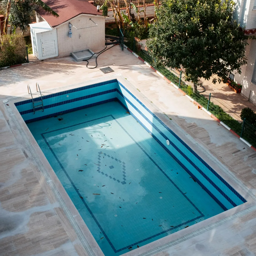 Rectangular custom inground swimming pool with deep blue water, stone paver patio coping, and built-in entry steps in Raleigh, NC.