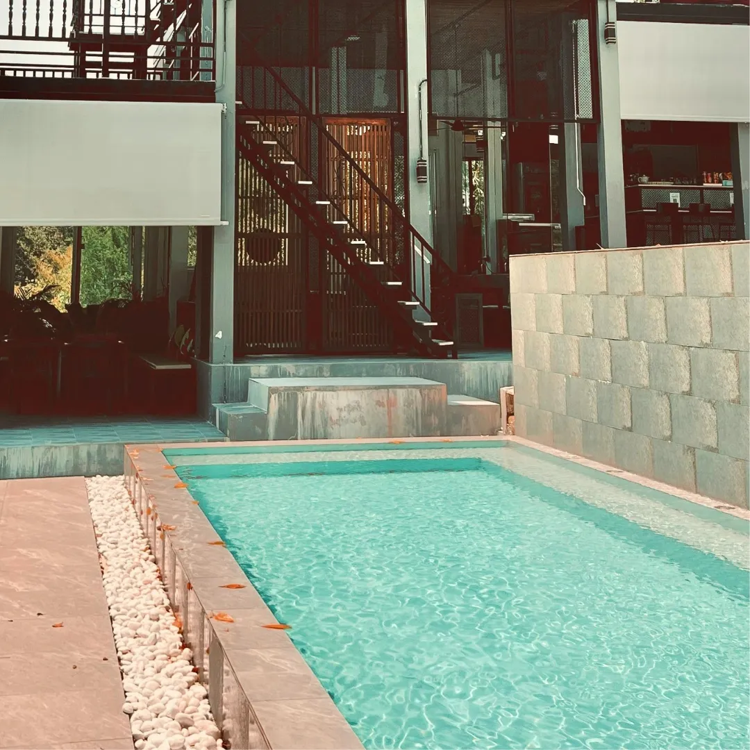 Narrow custom lap pool with light turquoise water and stone coping along a multi-level home patio in Raleigh, NC.