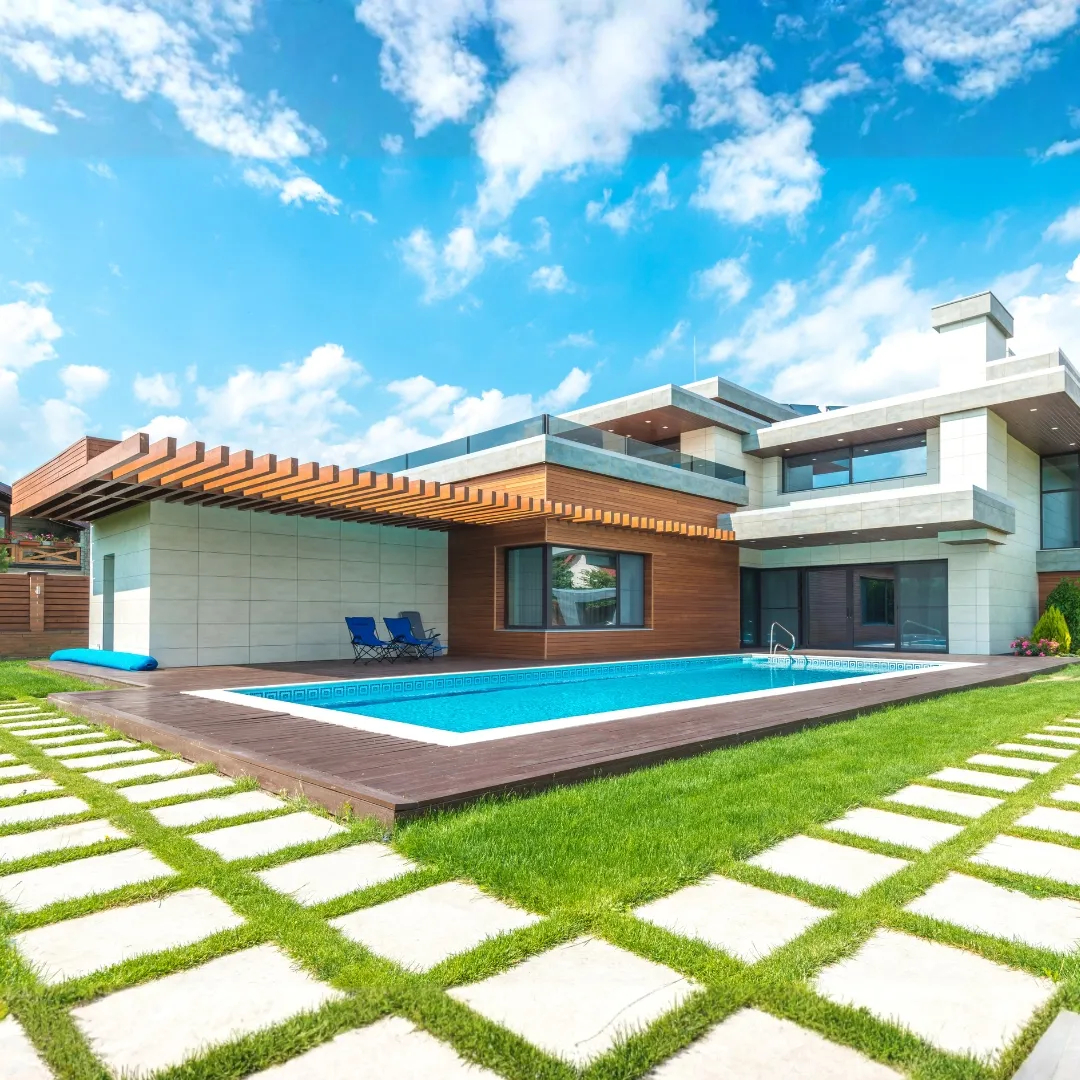 Modern luxury backyard featuring an inground swimming pool, square stone paver lawn grid, and contemporary outdoor patio design in Raleigh, NC.