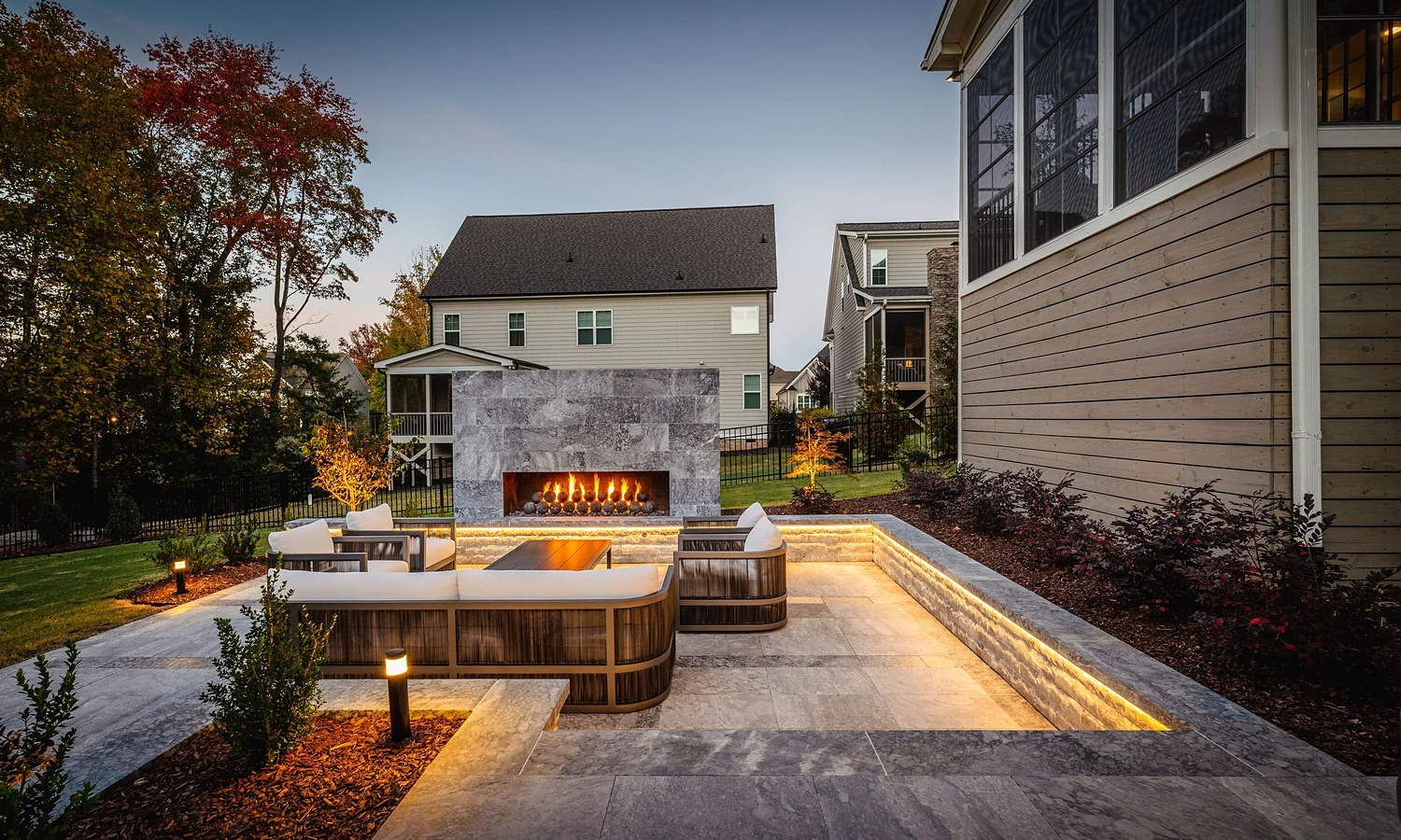 The best landscape design in Raleigh fits how you live. Front yards should welcome people in, backyards should give you room to relax and gather, and every part of the yard should work with Raleigh's soil, sun, and rain. Below, you'll find easy ideas for each area and a checklist to help you get started. Every yard in Raleigh is different. Some homes sit on big wooded lots in North Raleigh. Others have small, tight backyards inside the Beltline. But almost every homeowner wants the same thing: a yard that looks good and is actually easy to enjoy. This guide breaks landscape design in Raleigh into simple parts, so you can picture what's possible for your own home. Front yard vs. backyard: different jobs, one plan Your front yard and backyard do different jobs. A good plan treats them differently but still makes them feel connected. Front yard Backyard Main goal Make a strong first impression Create space to relax and gather Key features Walkways, clean beds, entry lighting Patios, seating, kitchens, fire features Plant style Neat, layered, easy to keep tidy Shade trees, privacy screens, soft borders Who uses it Guests and neighbors passing by You, your family, and friends Front yard landscape ideas for Raleigh homes Your front yard is the first thing people see. A few smart choices can change the whole look of your home. A welcoming walkway: A stone path from the driveway to the door feels inviting and safe. Layered planting beds: Short plants in front, taller shrubs behind, and a small tree for height. Clean edges: Crisp bed lines make the whole yard look cared for. Soft lighting: Path and entry lights add charm and safety at night. Backyard landscape ideas that make you want to stay outside The backyard is where life happens. That's why our backyard design work always starts with one question: how do you want to spend your time out here? For people who love to host A large custom patio with room for a table and lounge seating An outdoor kitchen so the cook isn't stuck inside Lighting that keeps the party going after sunset For people who want to unwind A cozy fire pit or outdoor fireplace Privacy planting along the fence line Quiet garden paths and seating nooks For families who want it all A luxury pool at the center of the yard Open lawn space for kids and pets Shade spots for hot afternoons Ideas for small and tricky Raleigh yards Not every yard is big and flat. The good news is that small or sloped spaces can look amazing with the right plan. Small yards: Use one main patio, keep plant choices simple, and add vertical interest with tall planters or a pergola. Sloped yards: Turn the slope into levels with retaining walls and steps. Each level can have its own purpose. Shady yards: Choose shade-loving plants and use stone or gravel where grass won't grow. Wet spots: Fix drainage first, then plan beds and paths around it. Want to see how this looks in real life? Browse our portfolio of finished projects across the Raleigh area. Your Raleigh landscape planning checklist Use this list before you talk to a designer. It helps you get clear on what you want. Walk your yard in the morning and evening and note where the sun hits Mark spots where water pools after rain List how your family wants to use the space Save photos of yards you love Think about future projects like a pool or outdoor kitchen Decide if you want help with care after the build Why one team for design, build, and care works better When different companies handle different parts of your yard, details get lost. At Currin Outdoor Living, the same team designs your yard, builds your landscape, and can keep it healthy with landscape maintenance. That means one point of contact, one clear plan, and fewer surprises. You can see how it all fits together on our process page. Let's design your Raleigh yard together Whether you're starting from scratch or refreshing an old yard, we'd love to help. Reach out to Currin Outdoor Living to talk about your ideas, and we'll help you turn them into a clear, beautiful plan. Frequently asked questions What is the best time of year to start landscape design in Raleigh? You can start the design any time of year. Many homeowners plan in fall and winter so the yard is ready to enjoy by spring and summer. Fall is also a great season for planting in Raleigh. Contact our team to get your project on the calendar. Can you make a small Raleigh backyard feel bigger? Yes. Smart layouts, clean lines, and a single main gathering area can make a small yard feel open and useful. Adding height with trees, pergolas, or tall planters also helps. See how we approach small spaces through our backyard design service. Should I design my front yard and backyard at the same time? It's a good idea to plan both together, even if you build them at different times. A single plan keeps the style, plants, and materials consistent around your home. Our landscape design team can map out both areas in one go. How do I add privacy to my Raleigh backyard? The most natural way is with layered planting, like evergreen shrubs and trees along the property line. Fences, walls, and pergolas can also help. A designer will choose the right mix for your yard as part of our landscape services. Can you add a pool to my landscape design later? Yes, and it's smart to plan for it now. Leaving the right space and access during your landscape design makes adding a pool much easier later on. Learn more about our pool design process. What makes a landscape low maintenance? Picking plants that like Raleigh's climate, using mulch, adding good drainage, and choosing durable hardscapes all reduce upkeep. A smart irrigation setup helps too. If you'd rather not do the work yourself, our landscape maintenance team can take care of it. Do you only work in Raleigh? No. We're based in Raleigh, but we also design and build yards in nearby towns like Cary, Apex, Holly Springs, Wake Forest, and Durham. View our full list of service areas.