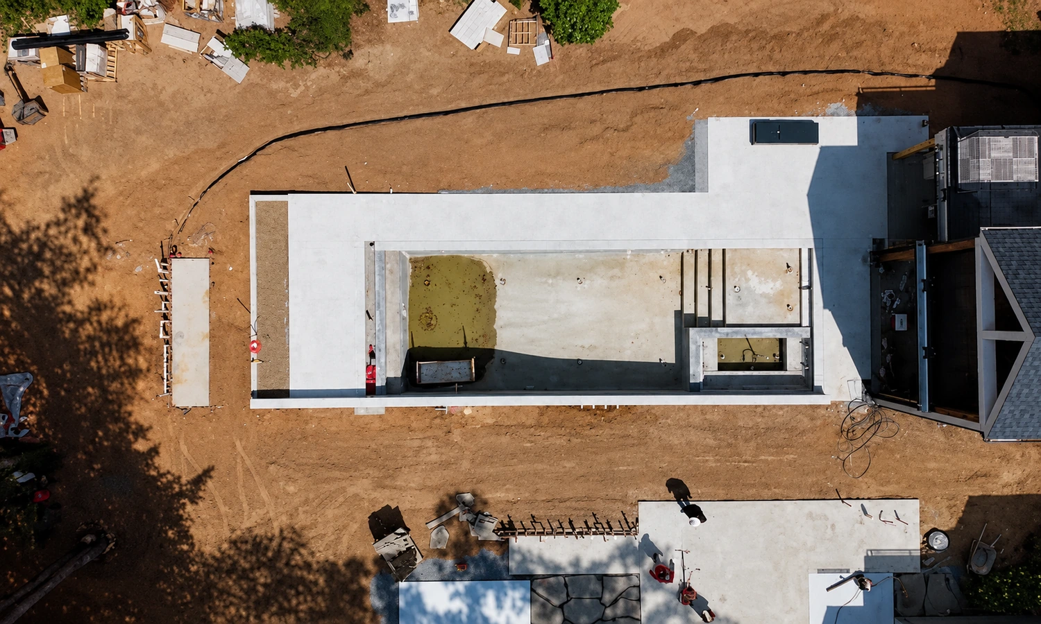 Aerial view of custom vertical pool layout and retaining wall construction on a sloped lot in Raleigh NC