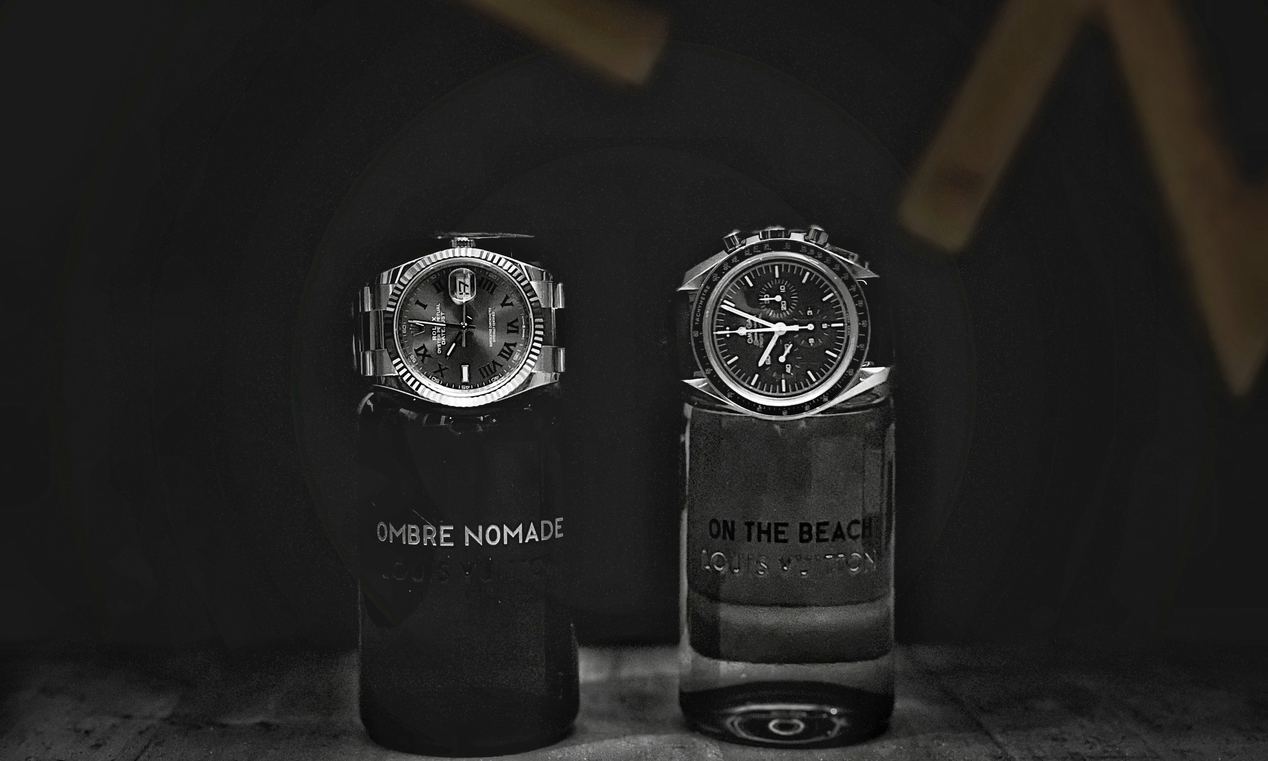 an omega speedmaster and a rolex datejust sitting side by side