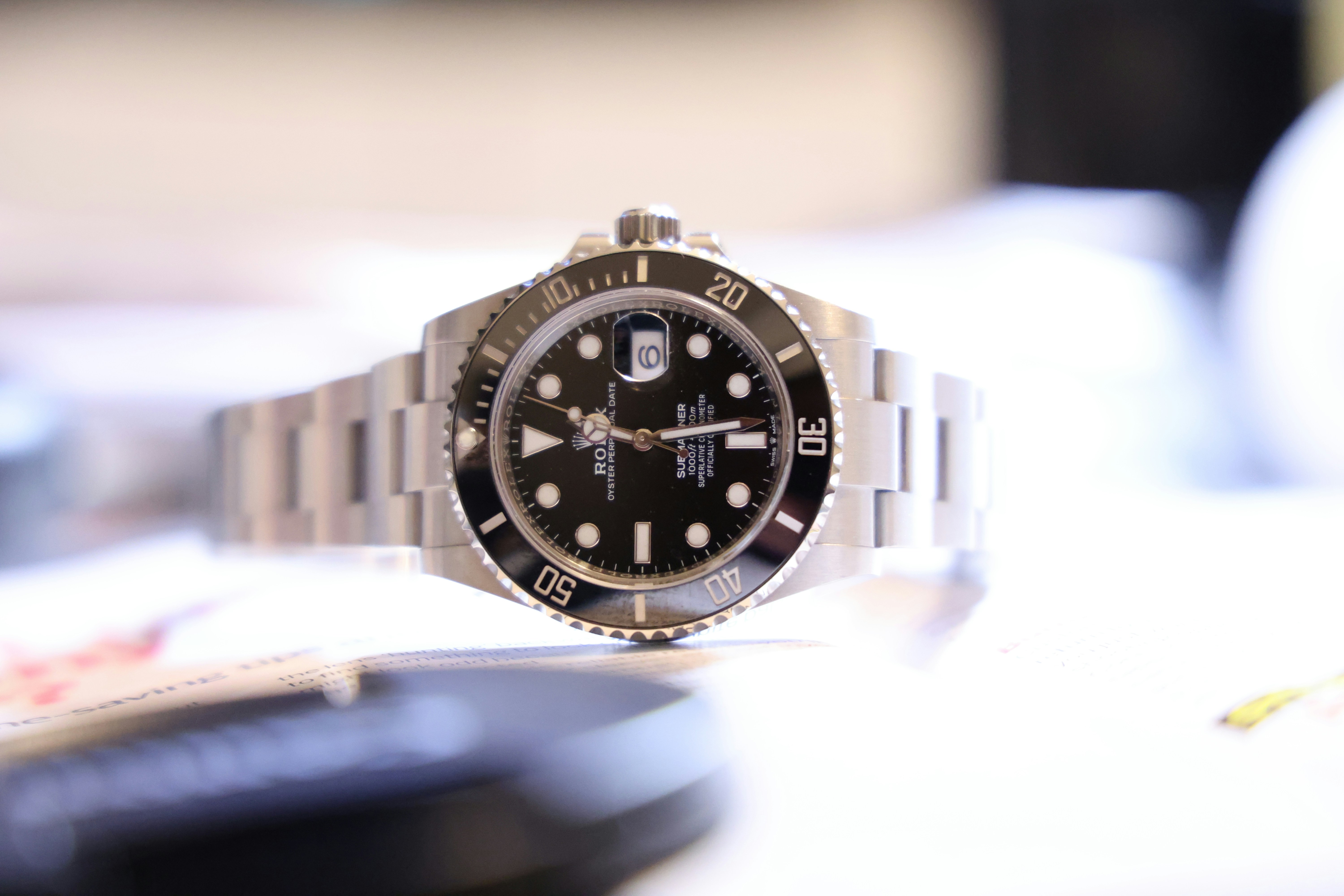 a rolex submariner sitting on its side on a tabletop