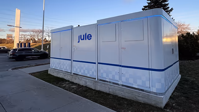 Jule's Hub in a parking lot powering a 5G tower in the background. 