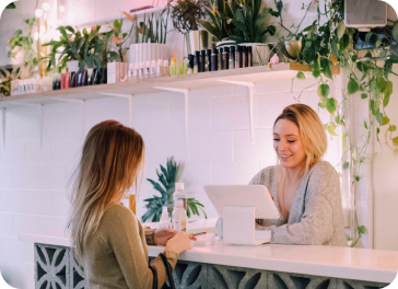 Two people talking at the counter of a small shop