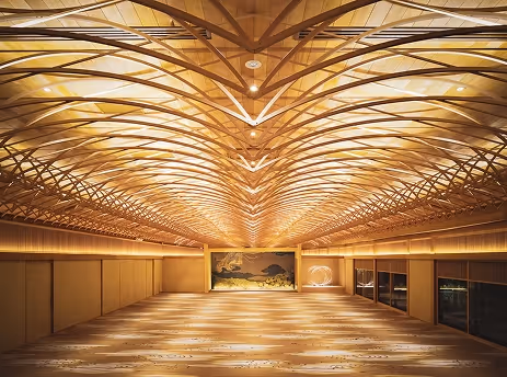 精巧な木製格子天井が特徴的な広く明るい和風の室内空間。