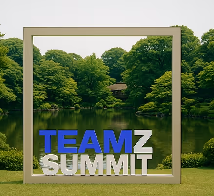 緑豊かな公園の池を背景にした白と青の『TEAMZ SUMMIT』の文字が枠内に配置されている景色。