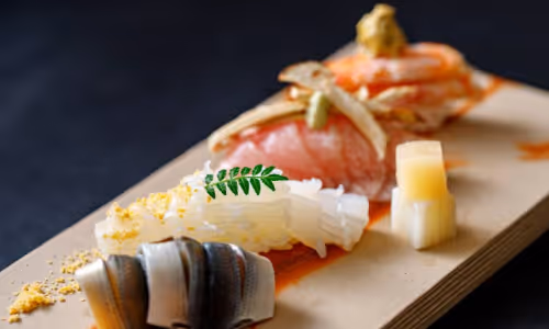 寿司の盛り合わせ、さまざまな種類の魚と魚卵が木の板に美しく盛られている。