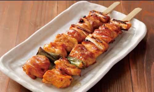 焼き鳥の串が2本、白い皿に乗っている。