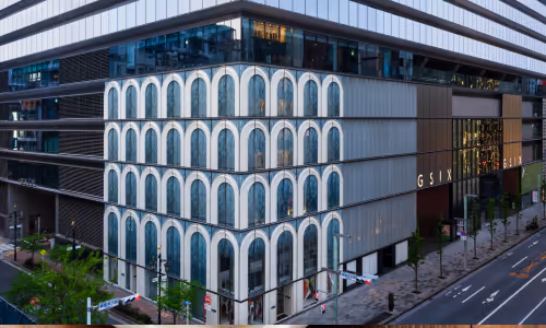 複数階にわたって無数のアーチ型窓が特徴的な近代的な商業ビル、GSIXの外観。