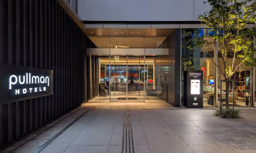 夜の照明がついたPullman Hotelsの入口と自動ドア。