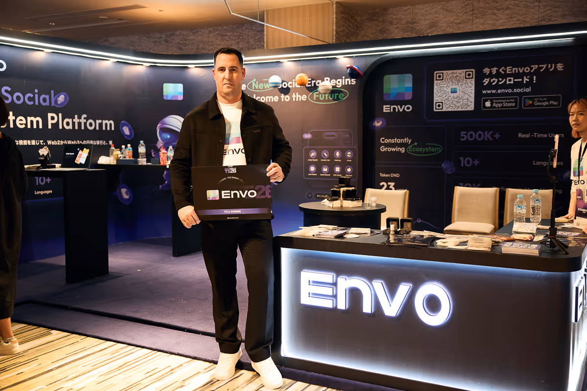 Envoブランドの展示ブースで、Envoの看板を持つ男性と受付に立つ女性がいる。