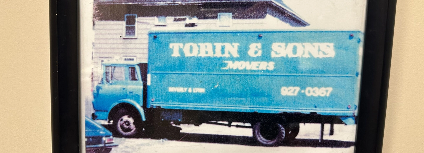 A blue truck parked in front of a building.