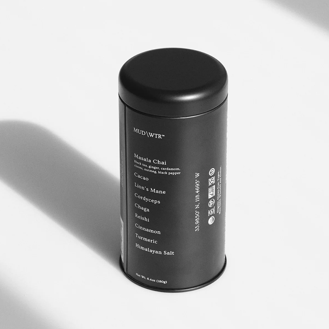 Black MUD\WTR tin on a white surface in soft shadow
