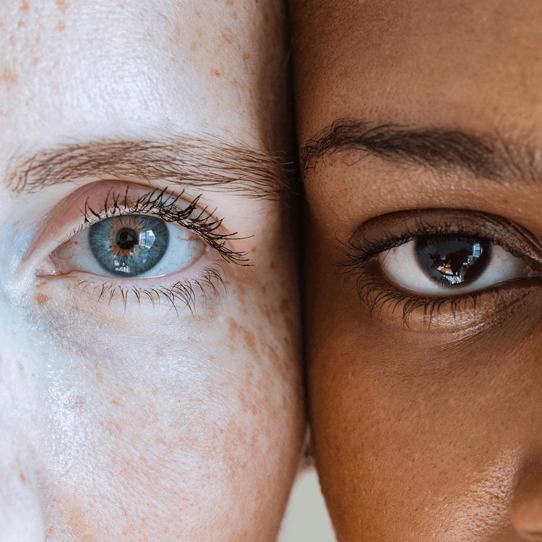 Close-up of two faces side by side, one with a blue eye and one with a brown eye