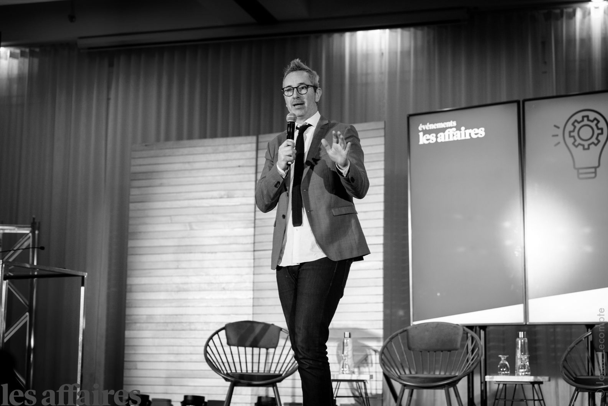 Francis Gosselin sur scène lors d'une conférence sur l'économie des médias