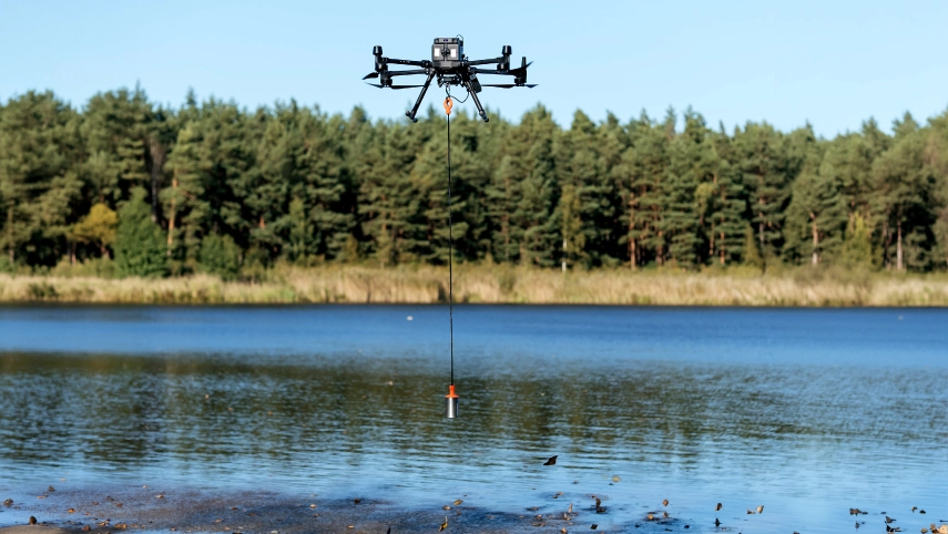 Drone-based hydrological survey over a river measuring water depth and flow