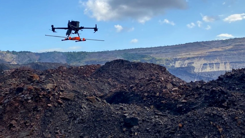 Drone flying over a mining site during a geophysical survey for mineral exploration
