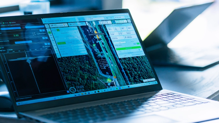 Researchers configuring a drone-mounted sensor system on a field worktable