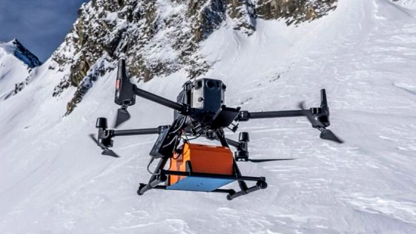 Drone equipped with ground-penetrating radar flying over a snow-covered glacier