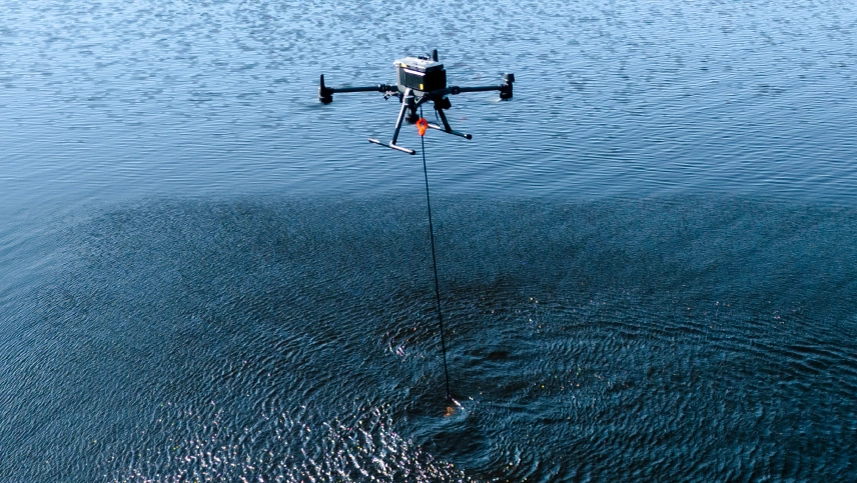 Drone with echo sounder sensor flying low over a lake for bathymetric mapping