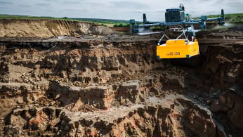Drone carrying a magnetometer sensor surveying an archaeological site