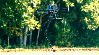Researchers configuring a drone-mounted sensor system on a field worktable
