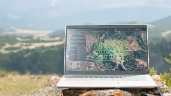 Researchers configuring a drone-mounted sensor system on a field worktable