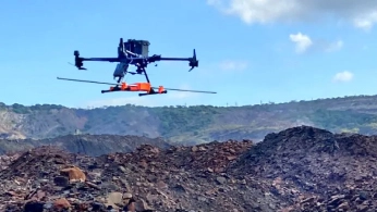 Researchers configuring a drone-mounted sensor system on a field worktable
