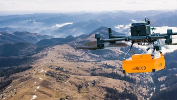 Researchers configuring a drone-mounted sensor system on a field worktable