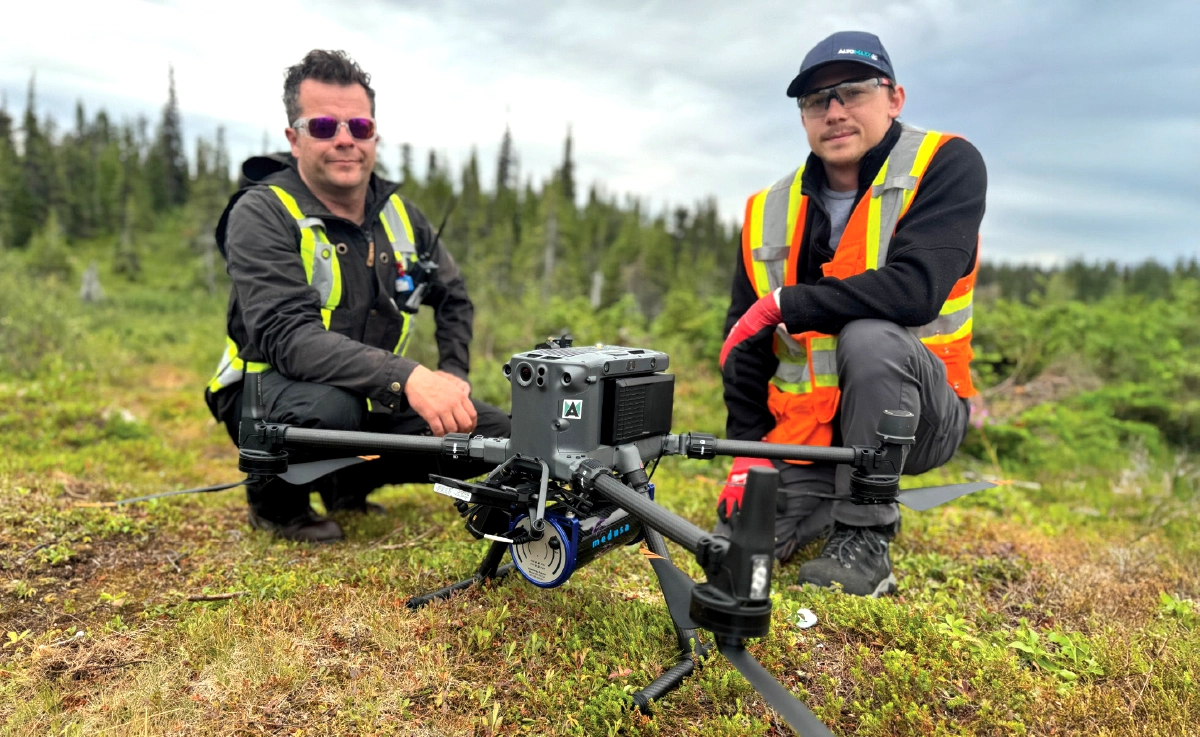 Two Altomaxx operators kneeling beside the drone-mounted MS350 spectrometer in northern Labrador