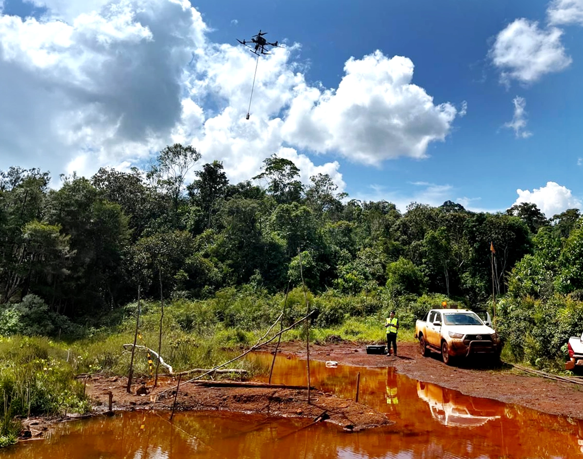 DJI Matrice 350 RTK carrying an Echologger ECT D052S echo sounder over a swampy mining water body in Indonesia.