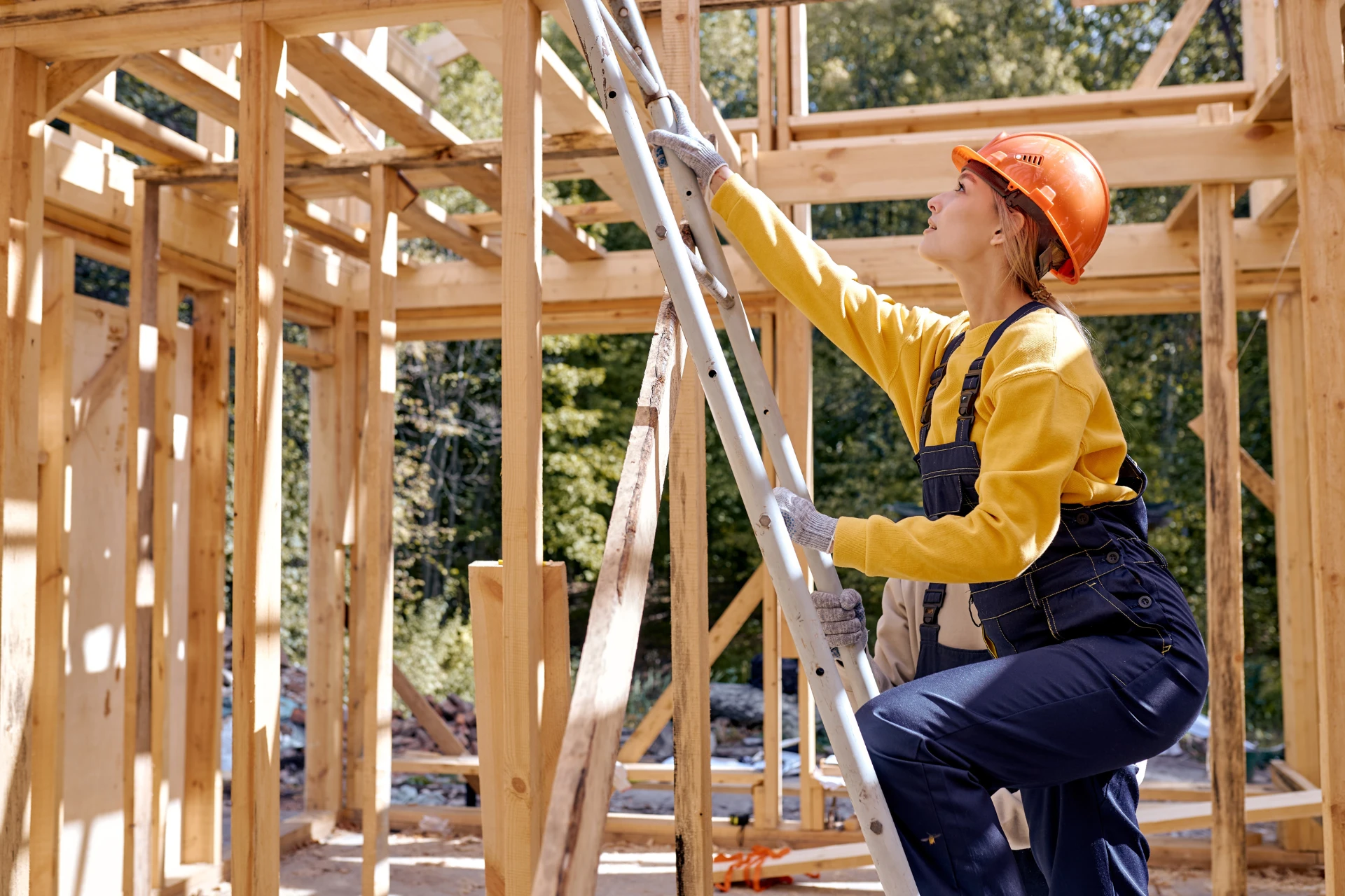 Construction worker climbing a ladder on site
