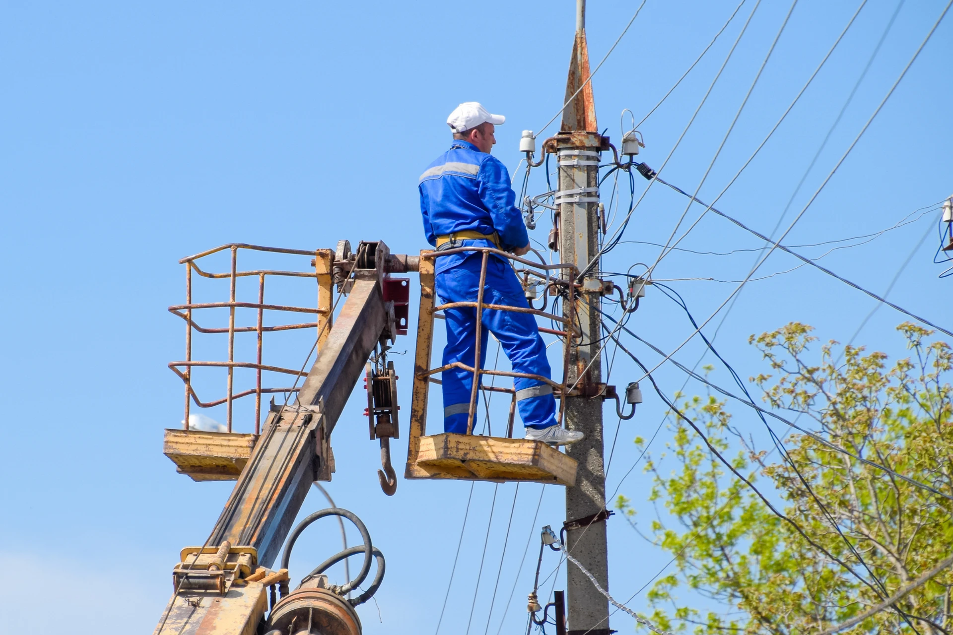 An electrician working on a power pole