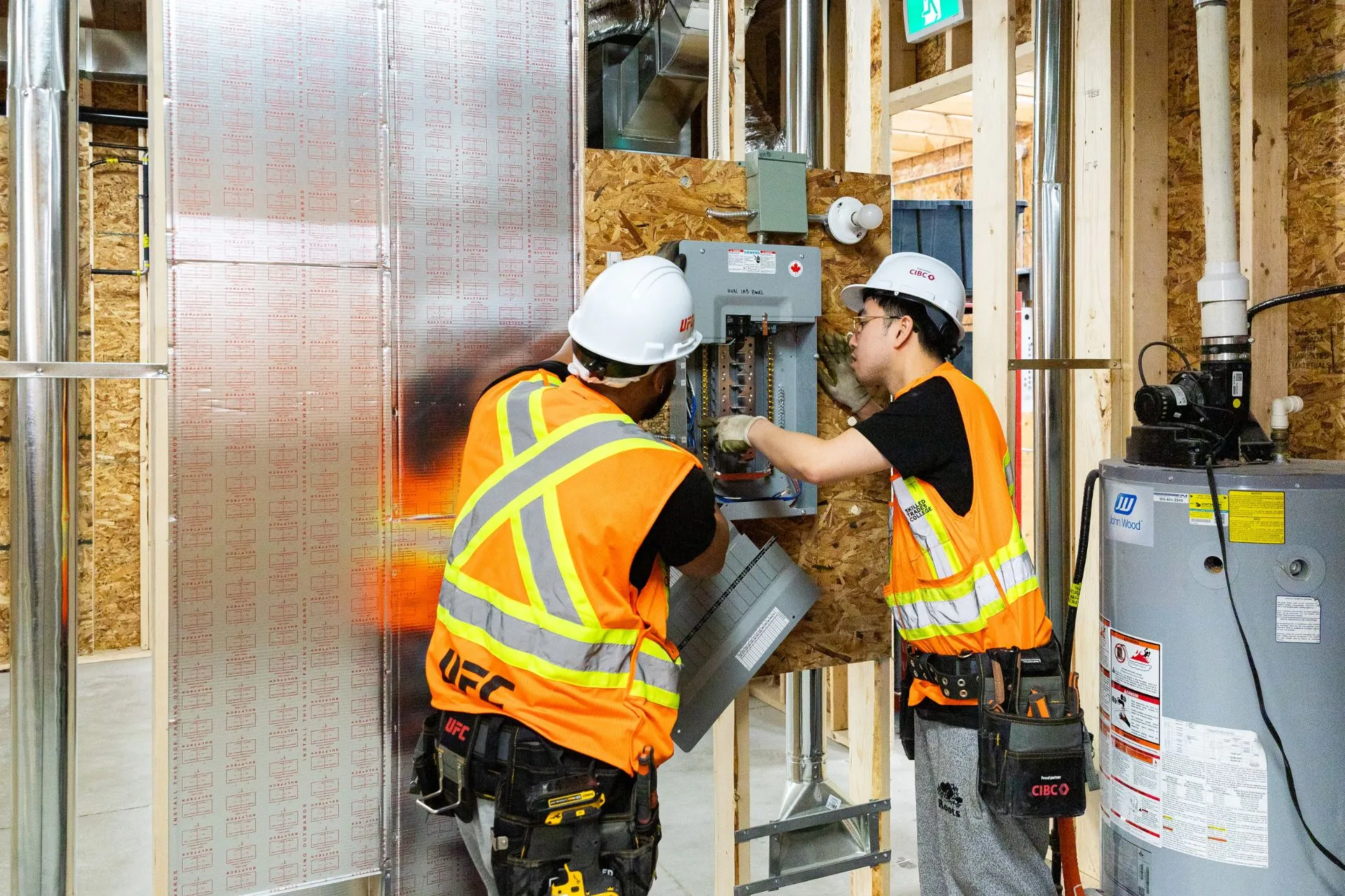 Two tradespeople checking an HVAC unit