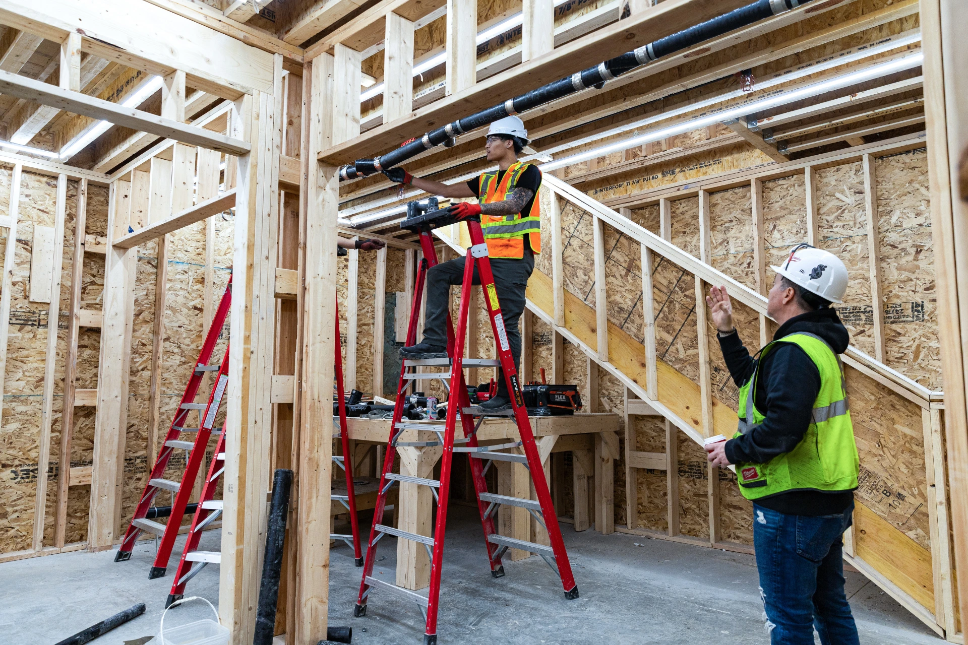 Pre-apprentice at Skilled Trades College of Canada fixes a pipe with guidance from an instructor 